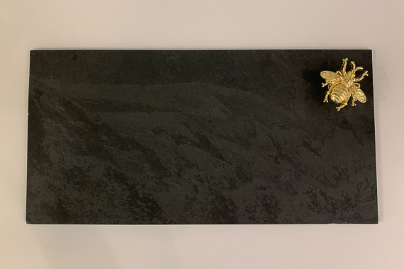 Bandeja preta da Lykke com detalhe de abelha dourada